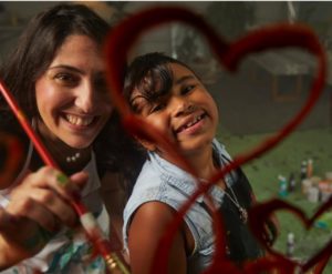 Big & Little Sister painting hearts on glass